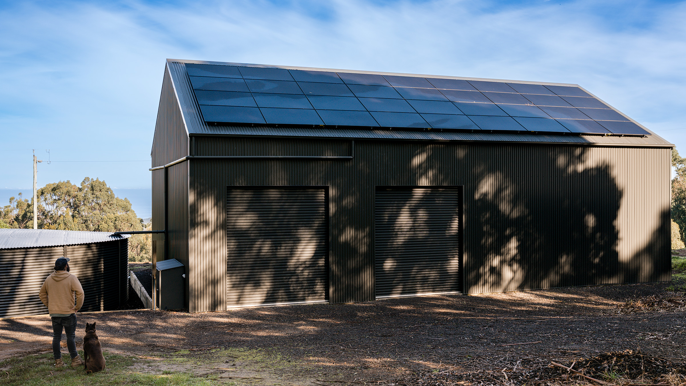 Jonno beside the completed Anker SOLIX solar and battery installation.